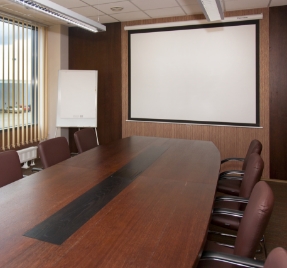 A meeting room with big screen and whiteboard at the back