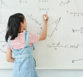 A girl doing maths on a whiteboard