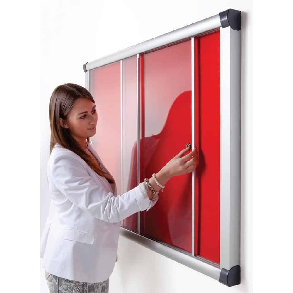 woman closing a red sliding showcase with an aluminium frame