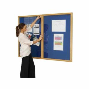 woman shutting a lockable noticeboard