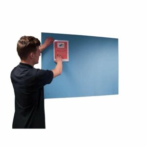 man putting a poster on a blue unframed noticeboard